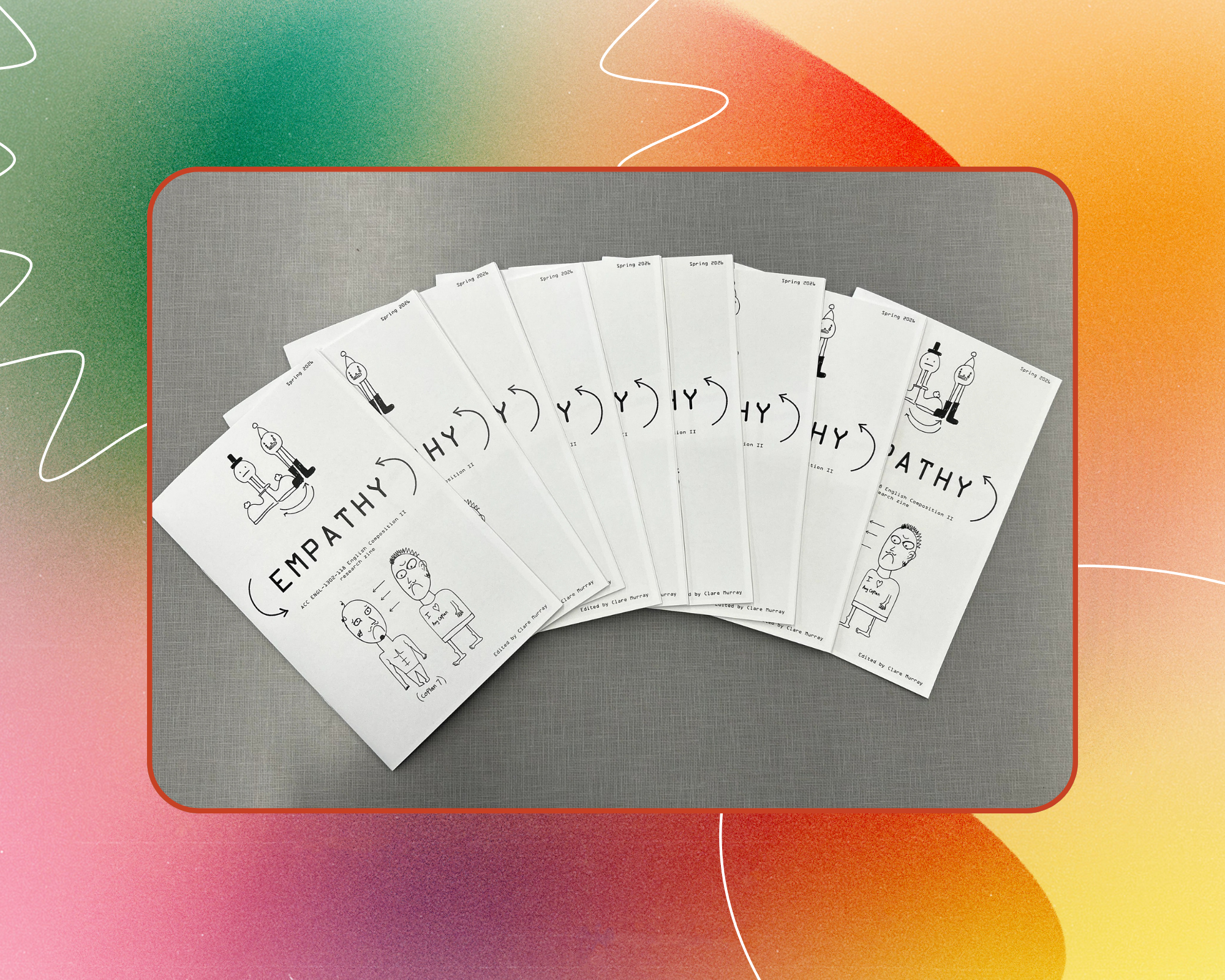A promotional graphic displaying multiple fan-folded printed zines arranged in an arc, each featuring stick-figure illustrations and lettering that spells out "EMPATHY" across the covers.