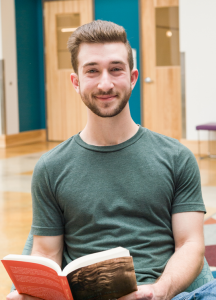 Student posing with book